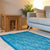  Pure Wool Felted Floral Rug. Turquoise colour in a room with decorative items and sofa.