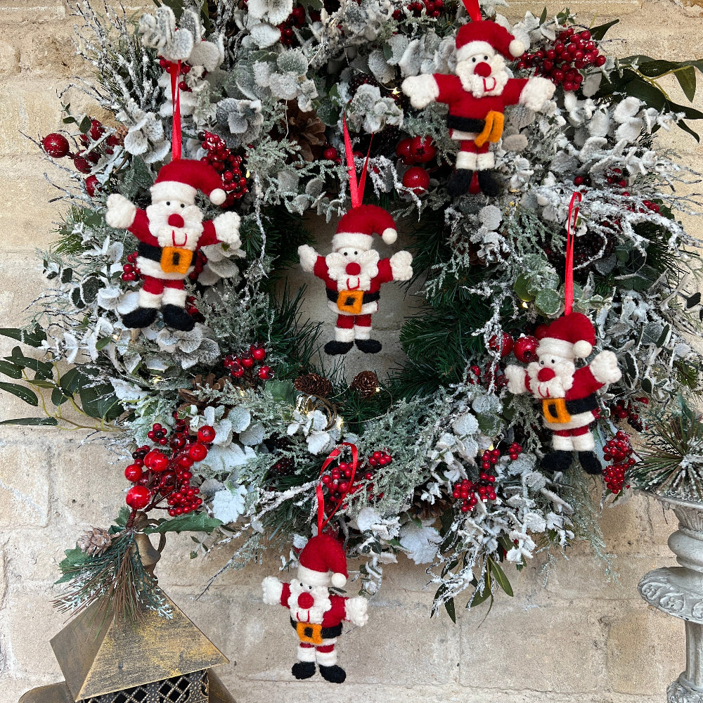 Douée -This charming Father Christmas ornament brings timeless elegance to your festive décor.

Crafted from premium New Zealand felted wool, each piece features hand-applied embellishments and delicate embroidery that showcase artisanal quality.  He&#39;s the perfect size for tree displays or shelf arrangements. Shown on a Christmas wreath against a cotswold stone wall with festive lantern candles. 